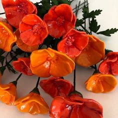 an arrangement of orange flowers on a white surface