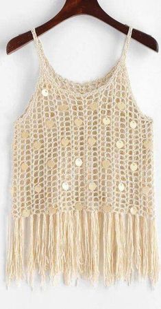 a crocheted crop top with fringes and buttons on the front, hanging on a wooden hanger