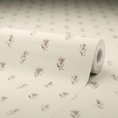 a roll of white paper with pink flowers printed on the side and dots in the background