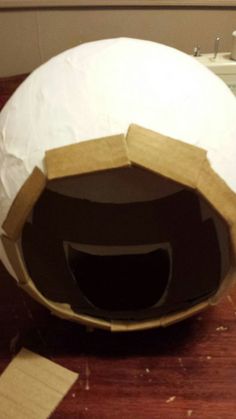 a paper mache helmet sitting on top of a wooden table