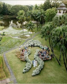 an aerial view of a wedding ceremony in the middle of a garden with lots of greenery