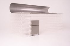 a silver refrigerator sitting in front of a metal object on top of a white floor