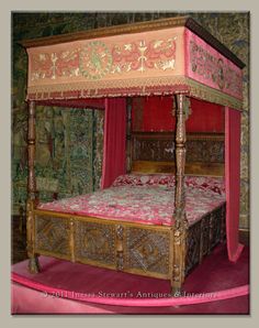 an ornate bed with pink canopy and red drapes