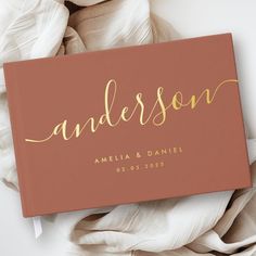 a brown and gold wedding guest book with the word's name in gold on it