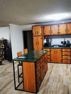 an empty kitchen with wooden cabinets and green counter tops in the middle of the room