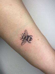 a small black and white bee tattoo on the right arm, it looks like he is ready to fly