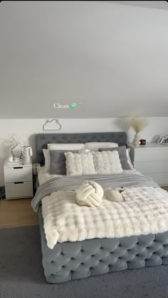 a bedroom with a bed, nightstands and white furniture in the corner is shown