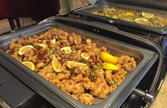 two trays filled with food sitting on top of a counter next to each other