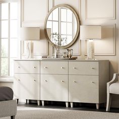 a white dresser with a round mirror above it