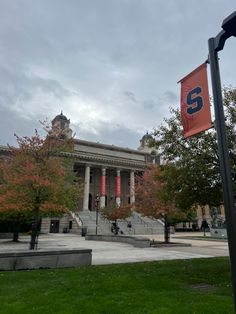 an orange and blue flag is in front of a building with steps leading up to it