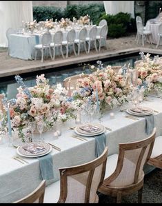 a long table is set with flowers and candles for a formal dinner or wedding reception