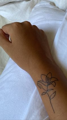 a person's arm with a flower tattoo on the left side of their arm