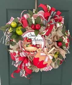 a wreath is hanging on the front door with apples and other things around it that says sweet autumn