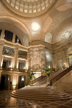 the interior of a large building with stairs and chandeliers on either side of it