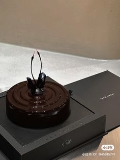 a chocolate cake sitting on top of a black box