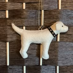 a white dog is hanging on a wooden wall