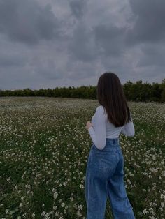 a woman standing in the middle of a field