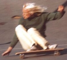 a woman riding a skateboard down a street