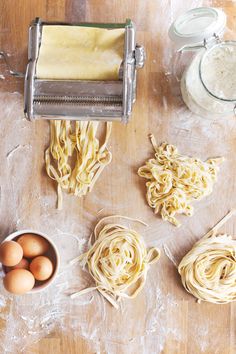 pasta being made on a wooden table with eggs and other ingredients around the doughnuts