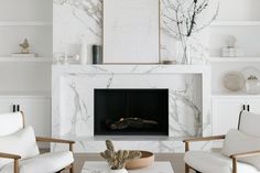 a living room with white furniture and a fireplace