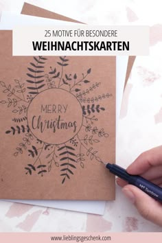 a hand holding a pen and writing merry christmas on top of a card with the words, 25 motivve fur resonderen der wehnachtskarten