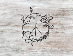 a peace sign with flowers and leaves drawn on the side of a piece of wood