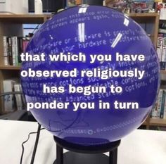 a large blue ball sitting on top of a table next to a bookshelf