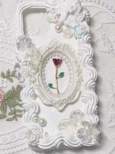 an ornate white frame with a rose on it