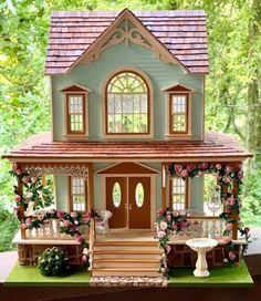 a doll house with flowers on the front porch