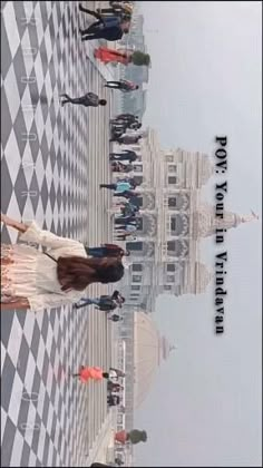 a group of people standing on top of a checkered floor next to tall buildings