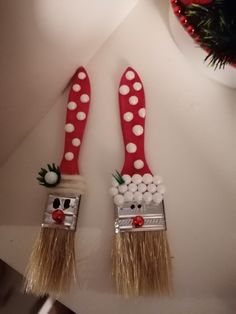 two red and white toothbrushes decorated to look like santa's feet with decorations on them