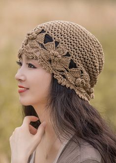 a woman wearing a crocheted hat with flowers on it