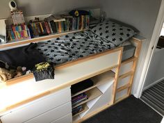 there is a bed with bookshelves and stuffed animals on the bottom shelf next to it