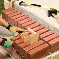 two bricklayers laying bricks on the ground