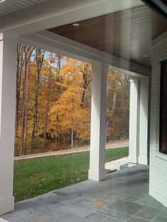 an outdoor covered porch with white pillars and columns