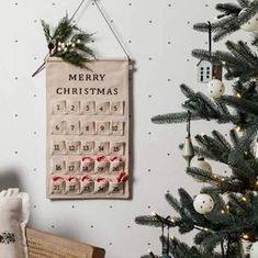 a christmas calendar hanging on the wall next to a tree