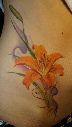 an orange flower on the side of a woman's stomach with swirls around it