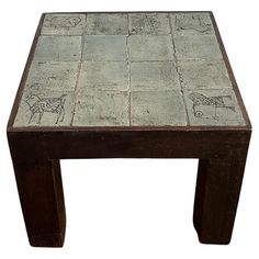 a small wooden table with drawings on the top and bottom, sitting in front of a white background