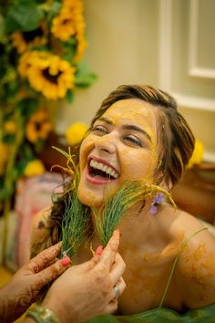 a woman is covered in mud and flowers