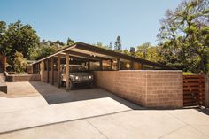 a car is parked in front of a brick wall with a garage attached to it