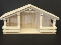 a small wooden dog house made out of wood planks and painted in white paint