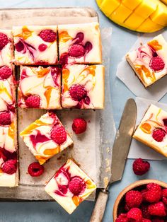 raspberry cheesecake squares with white frosting and fresh raspberries