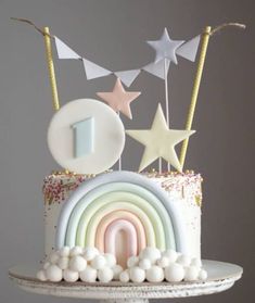 a birthday cake decorated with stars and rainbows