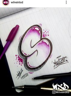 the letter g is drawn on top of a piece of paper next to a pen