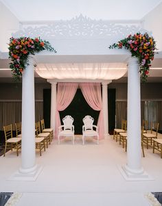 a wedding ceremony with white chairs and pink drapes