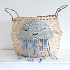 a basket with a jellyfish design on the front and sides, sitting on a shelf