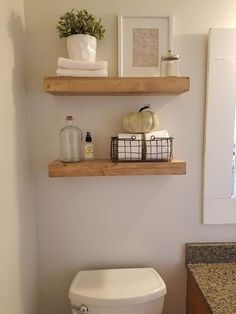 two shelves above a toilet in a bathroom