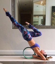 a woman is doing yoga with a hoop