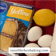 a box of yellow cake next to eggs and an orange