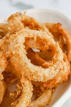 fried onion rings in a white bowl on a table